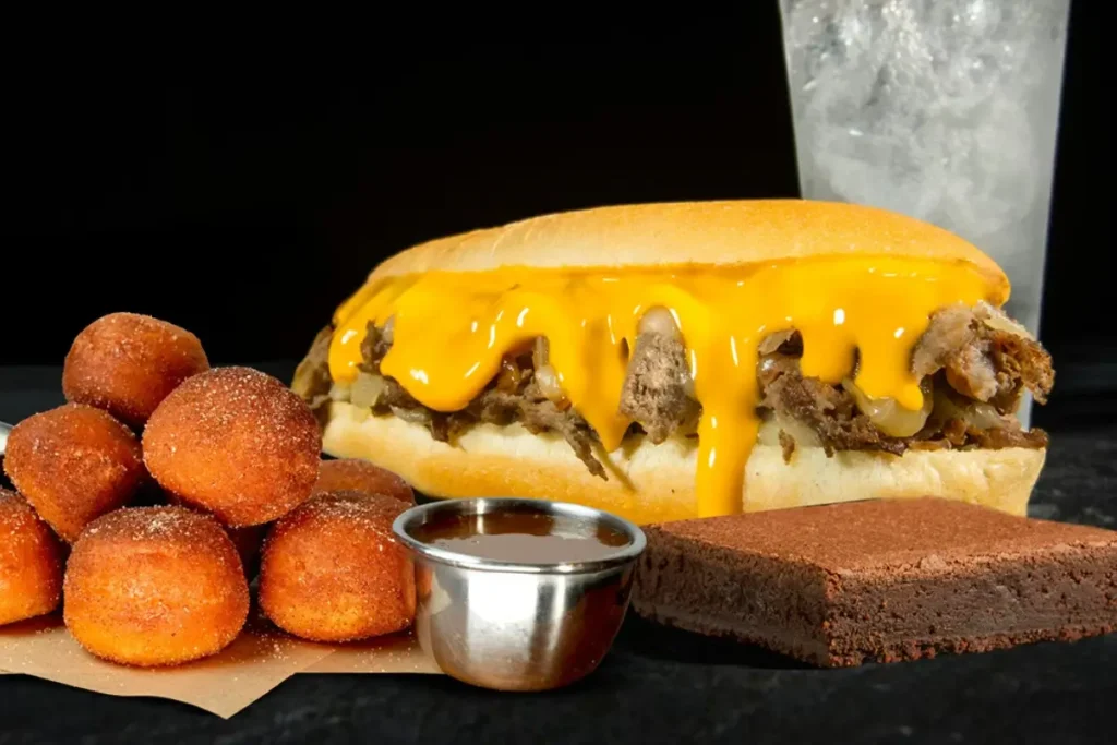 The Big One combo meal with a cheesesteak sandwich, donut dippers with caramel sauce, a brownie, and a drink